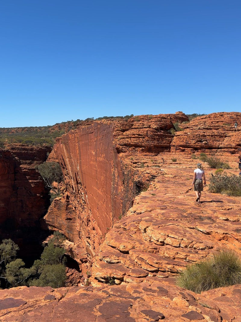 Hiker on the red sandstone rim of Kings Canyon, Northern Territory, Australia