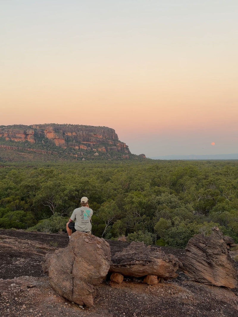 Hiker on the rocks at Nawurlandja Lookout at sunset, Kakadu, Northern Territory, Australia