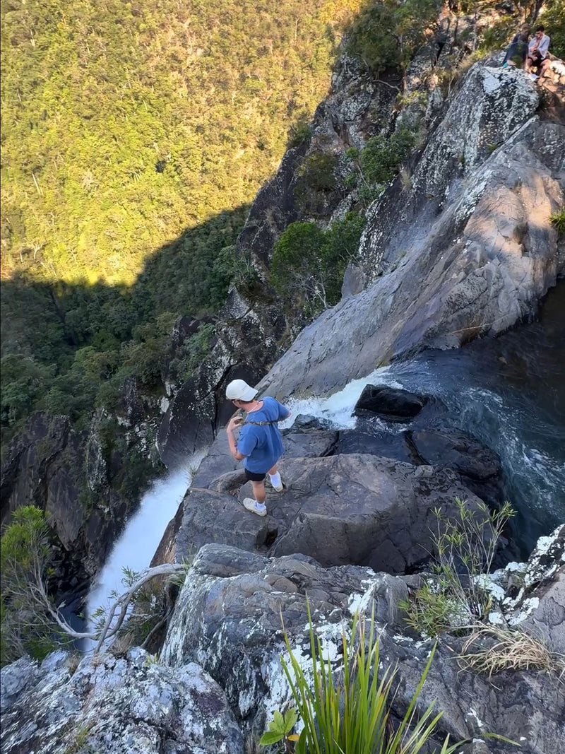 Hiker at the top of Windin Falls above a forested gorge in Far North Queensland, Australia